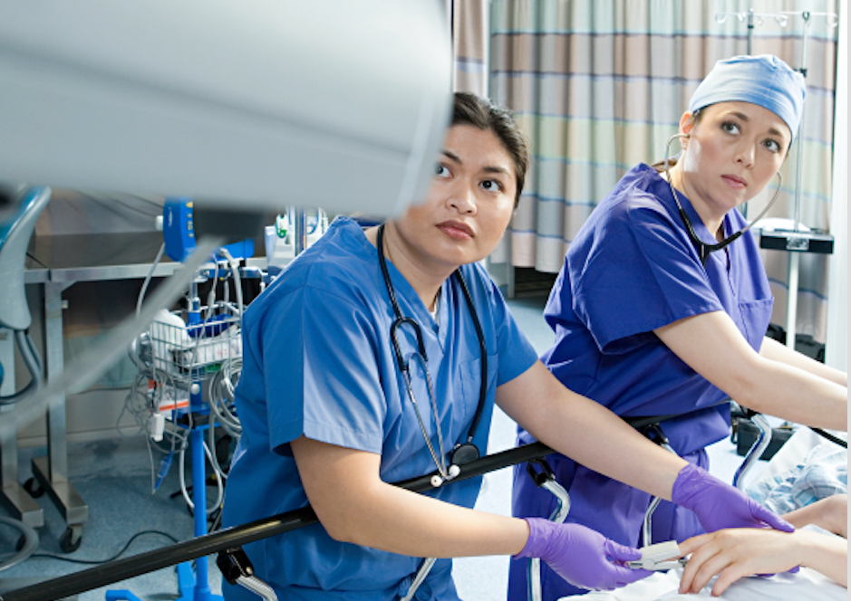 Decorative image of medical staff looking at monitoring equipment in hospital 