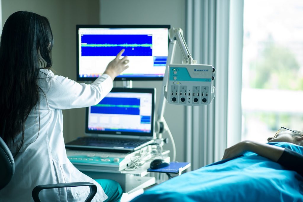 Decorative image of person in front of medical monitoring equipment in a hospital room